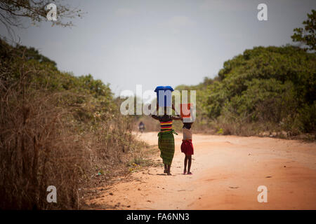 Mädchen nach Hause vom Wasserholen an einen Accesspoint im Mecupes Dorf, Mosambik. Stockfoto