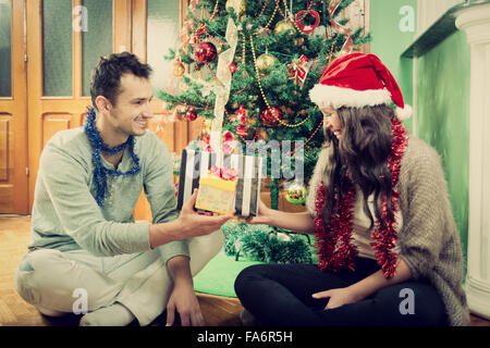 Glückliches Paar Austausch von Geschenken zu Hause Weihnachtsbaum, präsentiert Neujahr Feier Konzept mit zwei Personen geben Stockfoto