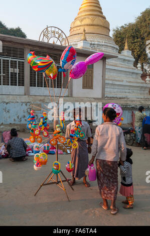 Hawker, Verkauf von bunten Luftballons auf einem Straßenmarkt in den frühen Morgenstunden in Shwe Kyet noch, Region Mandalay, Myanmar. Stockfoto