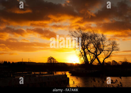 Rufford, Lancashire, UK. 23. Dezember 2015. Ein schöner Sonnenaufgang erhebt sich über die sanften Hügel der Pennine, erfüllten die ruhenden Kanalboote in Rufford Marina in Lancashire. Die ungewöhnlich warme Witterung geht weiter in der Urlaubszeit, so dass die Chancen auf eine weiße Weihnacht ziemlich schlank. [Bild von öffentlichen Flächen]  Bildnachweis: Cernan Elias/Alamy Live-Nachrichten Stockfoto