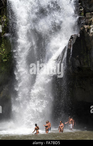 Touristen genießen ein Bad im Tegenungan Wasserfall in der Nähe von Ubud, Bali, Indonesien Stockfoto