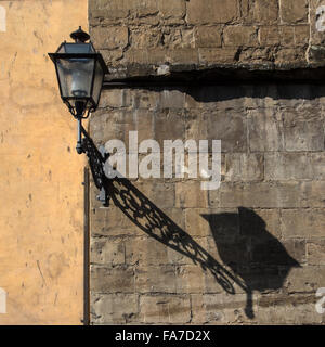 FLORENZ, ITALIEN - 06. AUGUST 2015: Alte Laterne mit Schatten an der Wand des Gebäudes in Florenz, Italien Stockfoto