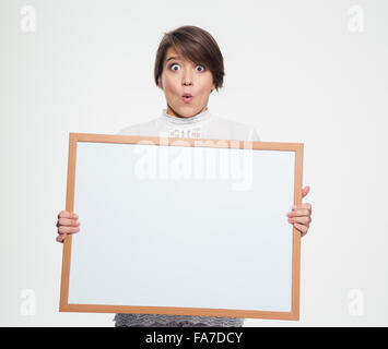 Erstaunt lustige junge Frau Mking lustiges Gesicht und leere Board Holding über weißem Hintergrund Stockfoto