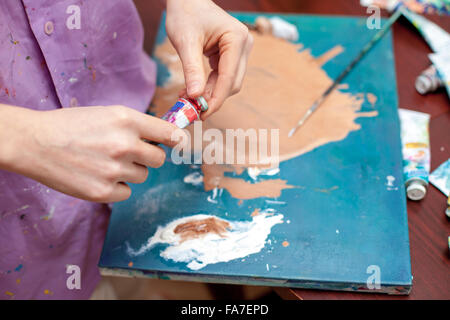 Des Künstlers Hände close-up auf dem Hintergrund der palette Stockfoto