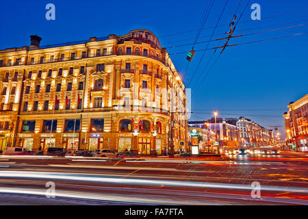 Gebäude an der Ecke der Mokhovaya und Tverskaya Straße beleuchtet in der Abenddämmerung. Moskau, Russland. Stockfoto