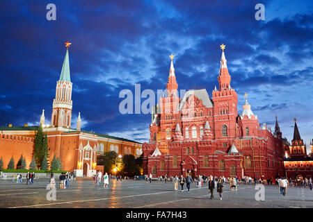 Menschen, die in der Abenddämmerung auf dem Roten Platz vor dem State Historical Museum spazieren gehen. Moskau, Russland. Stockfoto