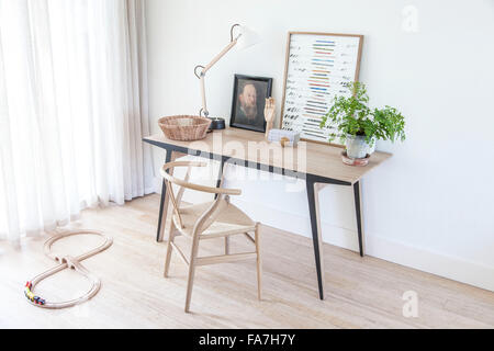 Schreibtisch in der Ecke des Wohnzimmers in einem modernen Landhaus in Cambridge. Ein Haus verbindet modernen minimalistischen Stil mit Anzeige der traditionelle Objekte, die im täglichen Leben verwendet. Stockfoto