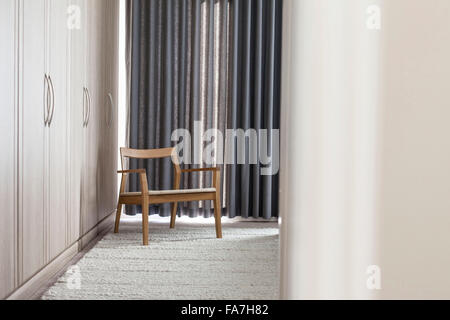 Ein Design-Stuhl in der Ecke des Schlafzimmers. Ein Haus verbindet modernen minimalistischen Stil mit Anzeige der traditionelle Objekte, die im täglichen Leben verwendet. Stockfoto