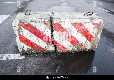 Betonstraße mit Warnung rot-weiß diagonal gestreift Blockmuster Stockfoto