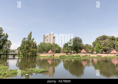 BLOEMFONTEIN, Südafrika, 21. Dezember 2015: Picknick Plätze auf Loch Logan Insel mit einem Apartment-Hochhaus in der bac Stockfoto