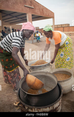 Reis ist parboiled, vor dem Verkauf an eine Gruppe Verarbeitung Frauenzentrum in Sourou Provinz, Burkina Faso. Stockfoto