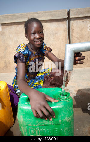 Mädchen bekommen frisches Wasser aus einem Brunnen in Kouka Abteilung in Burkina Faso, W. Afrika. Stockfoto