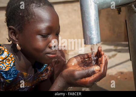 Mädchen bekommen frisches Wasser aus einem Brunnen in Kouka Abteilung in Burkina Faso, W. Afrika. Stockfoto