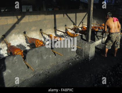 Quezon City, Philippinen. 23. Dezember 2015. Ein Filipino Arbeiter reinigt ein gebratenes Schwein seine Öle bei Vorort Quezon City, östlich von Manila, Philippinen. Gebratenes Schwein, genannt "Lechong Baboy" oder einfach "Lechon" ist eine beliebte Delikatesse während der Weihnachtszeit in den Philippinen. Das Land feiert die längste Weihnachtszeit in der Welt, die bereits im September beginnt. © Richard James M. Mendoza/Pacific Presse/Alamy Live-Nachrichten Stockfoto