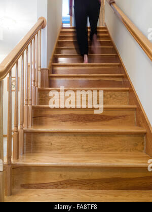 Frau zu Fuß hinauf Wohn Flug der Treppe, USA Stockfoto