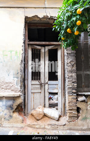 Alte Holztür und Rahmen auf ein verfallenes Haus im Bereich Exarchia von Athen, Griechenland Stockfoto