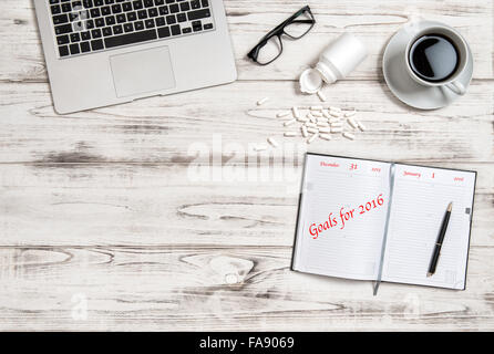 Büroarbeitsplatz mit Kalender-Buch, Kaffee und Medizin-Kapseln. Business-Konzept Ziele für das Jahr 2016 Stockfoto