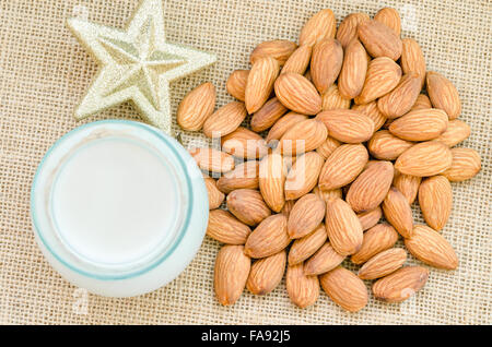 Mandelmilch mit Goldstern auf Sack Hintergrund. Stockfoto