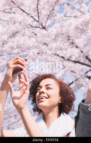 Junge Frau genießen Kirschblüten blühen in Tokio Stockfoto