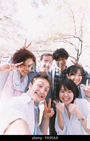 Multi-ethnischen Gruppe von Freunden genießen Kirschblüten blühen in Tokio Stockfoto