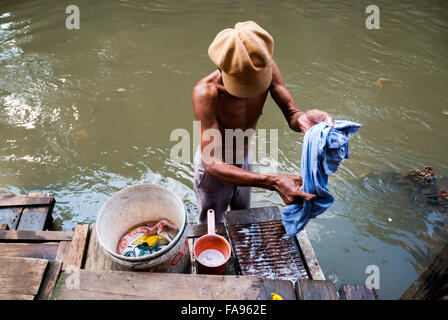 Man Wäsche waschen am Ciliwung riverbank, Jakarta. Ciliwung ist als eines der am stärksten verschmutzten Flüsse der Welt sagte. Stockfoto