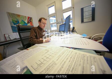 Mainz, Deutschland. 17. Dezember 2015. Herausgeber Andreas Krause arbeitet an Partituren in seinem Büro an Musik und Buch Musikverlag Schott Music in Mainz, Deutschland, 17. Dezember 2015. Eine wachsende Zahl von Musikern erhalten Noten aus dem Internet mit legalen und illegalen Mitteln. Viele Verlage haben immer noch Probleme beim Umgang mit der digitalen Revolution. Foto: FREDRIK VON ERICHSEN/Dpa/Alamy Live-Nachrichten Stockfoto