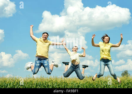 Glückliche Familie springen auf Himmelshintergrund Stockfoto