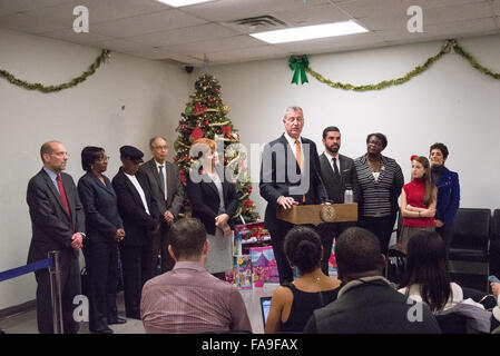 Brooklyn, USA. 23. Dezember 2015. Mayor de Blasio (Mitte, am Podium) spricht mit der Presse. Bürgermeister Bill de Blasio gemeinsam mit Human Resources Administration Kommissar Steven Banks und President/CEO von Win--"Frauen in Not" Tierheim Netzwerk--ehemaliger Stadtrat Sprecher Christine Quinn Geschenke an einem Einfamilienhaus in East New York verteilen. Bildnachweis: Albin Lohr-Jones/Pacific Press/Alamy Live-Nachrichten Stockfoto