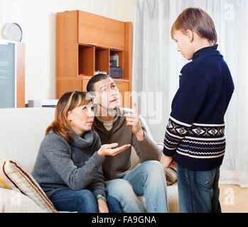 normale Eltern beschimpfen Teenager-Sohn im Wohnzimmer zu Hause. Mutter im Fokus Stockfoto