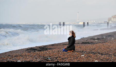 Brighton, Sussex UK 24. Dezember 2015 - eine junge Frau beobachtet die Wellen in Brighton Beach, wie Sturm Eva Großbritannien mit Stürme und Winde mit Böen von bis zu 80 km/h Credit hits: Simon Dack/Alamy Live News Stockfoto