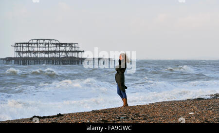 Brighton, Sussex UK 24. Dezember 2015 - eine junge Frau beobachtet die Wellen in Brighton Beach, wie Sturm Eva Großbritannien mit Stürme und Winde mit Böen von bis zu 80 km/h Credit hits: Simon Dack/Alamy Live News Stockfoto