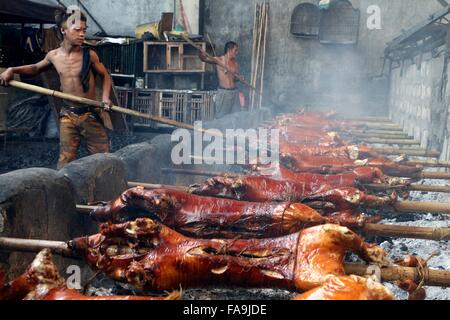 Manila, Philippinen. 24. Dezember 2015. Arbeiter der Brgy. Laloma in Quezon City sind immer beschäftigt, um die bestellten Lechon Baboy (gebratenes Schweinefleisch) für die Feier der Noche Buena kochen, nach der Lechonero (gebratenes Schweinefleisch kochen) kochen sie gebratene Schweinefleisch von 2 bis 3 Stunden. und es hängt von der Größe und sie noch in traditioneller Weise oder manuelle Drehung des Schweinefleisches Sicherstellung die Qualität von geröstetem Schweinefleisch kochen. Bildnachweis: Gregorio B. Dantes/Pacific Press/Alamy Live-Nachrichten Stockfoto