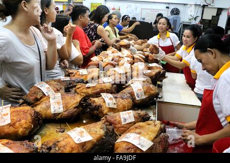 Manila, Philippinen. 24. Dezember 2015. Arbeiter der Brgy. Laloma in Quezon City sind immer beschäftigt, um die bestellten Lechon Baboy (gebratenes Schweinefleisch) für die Feier der Noche Buena kochen, nach der Lechonero (gebratenes Schweinefleisch kochen) kochen sie gebratene Schweinefleisch von 2 bis 3 Stunden. und es hängt von der Größe und sie noch in traditioneller Weise oder manuelle Drehung des Schweinefleisches Sicherstellung die Qualität von geröstetem Schweinefleisch kochen. Bildnachweis: Gregorio B. Dantes/Pacific Press/Alamy Live-Nachrichten Stockfoto