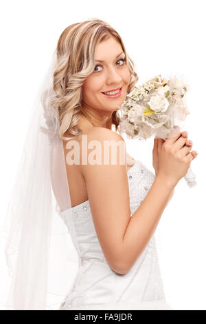 Vertikale Aufnahme einer jungen Braut im weißen Hochzeitskleid Hochzeit Blumenstrauss halten und in die Kamera schaut Stockfoto