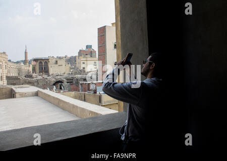 Kairo, Ägypten. 24. Dezember 2015. Die junge ägyptische fotografieren aus in einer Moschee Ali Bek Abou El Dahab im fatimidischen Kairo. Weitläufige Hauptstadt Kairo, Ägypten, befindet sich auf dem Nil. In seinem Herzen ist, Tahrir-Platz und das große ägyptische Museum, eine Fundgrube für Antiquitäten, einschließlich der königlichen Mumien und vergoldeten König Tutankhamun Artefakte. In der Nähe, ist Gizeh Standort der legendären Pyramiden und große Sphinx aus dem 26. Jahrhundert B.C.E In Insel Gezira grünen Zamalek Bezirk bietet 187 m Cairo Tower Panoramablick auf die Stadt. © Fuchs El-Geziry/Pacific Press/Alamy Live-Nachrichten Stockfoto