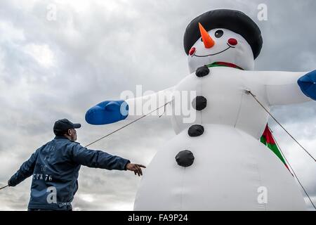 Ein US-Marine Seemann errichtet eine aufblasbare Schneemann auf dem Flugdeck des Flugzeugträgers USS Ronald Reagan zu feiern Weihnachten bei einem Port-Besuch 17. Dezember 2015 in Yokosuka, Japan. Stockfoto