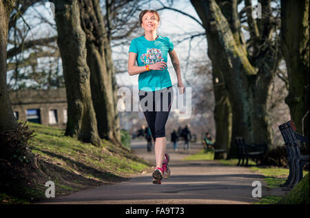 Eine Frau trägt ein Aktivitätsprotokoll Joggen in der Stadt von Bristol UK Stockfoto