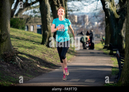 Eine Frau trägt ein Aktivitätsprotokoll Joggen in der Stadt von Bristol UK Stockfoto