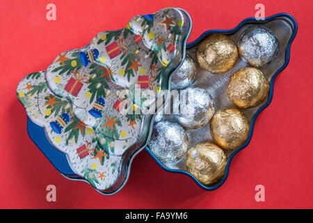 Weihnachtsbaum Zinn mit Folie überzogen Schokolade Kugeln - Pralinen bereit für Weihnachten auf rotem Hintergrund isoliert Stockfoto