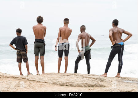 RIO DE JANEIRO, Brasilien - 22. Oktober 2015: Brasilianische Surfer in Neoprenanzüge stehen ankommenden Wellen am Arpoador betrachten. Stockfoto