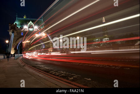 London Tower Bridge, UK, in der Nacht mit Autos und Bussen bunte leichte Spuren zu hinterlassen. Stockfoto