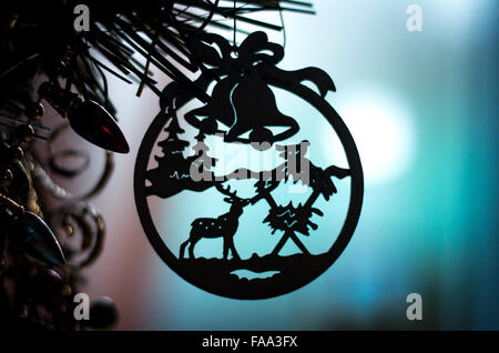 Silhouette von einer hölzernen Weihnachtsdekoration auf einen Weihnachtsbaum auf blauem Grund. Stockfoto