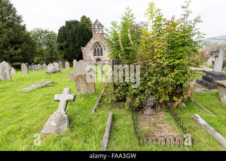 Überwucherte Grab Grundstück im Kirchhof mit schiefen Grabstein, Llanfoist, Wales, UK Stockfoto