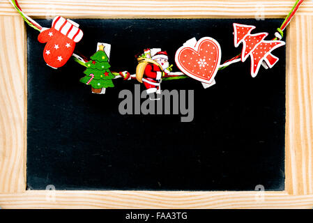 Weihnachts-Dekorationen auf Heringe über Vintage Kreidetafel mit Holzrahmen, Textfreiraum verfügbar Stockfoto