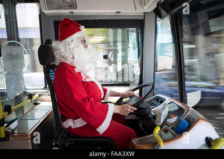 Buenos Aires, Argentinien. 24. Dezember 2015. Cristian Gabriel Tamasi, Treiber von der Buslinie 39, macht seine üblichen Route, verkleidet als Weihnachtsmann, in Buenos Aires, Hauptstadt von Argentinien, am 24. Dezember 2015. Cristian, 22-Year-Old, wurde ein Busfahrer für ein Jahr und eine Hälfte in der Firma wo arbeitet sein Vater auch. Er beschloss, gehen zur Arbeit verkleidet als Weihnachtsmann schenken Freude Passagiere und die Weihnachtsstimmung zu verbreiten. © Martin Zabala/Xinhua/Alamy Live-Nachrichten Stockfoto