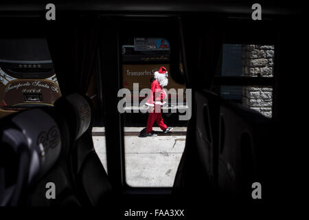 Buenos Aires, Argentinien. 24. Dezember 2015. Cristian Gabriel Tamasi, Treiber von der Buslinie 39, Spaziergänge vor Beginn seiner üblichen Route als Santa Claus, in Buenos Aires, Hauptstadt von Argentinien, am 24. Dezember 2015 gekleidet. Cristian, 22-Year-Old, wurde ein Busfahrer für ein Jahr und eine Hälfte. Er beschloss, gehen zur Arbeit verkleidet als Weihnachtsmann schenken Freude Passagiere und die Weihnachtsstimmung zu verbreiten. © Martin Zabala/Xinhua/Alamy Live-Nachrichten Stockfoto