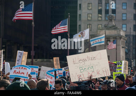 Chicago, USA.  24. Dezember 2015.  Hunderte von Menschen versammeln sich um unten Michigan Avenue "Magnificent Mile" Einkaufsviertel am Heiligabend zum protest gegen die angebliche Polizei vertuschen März im Zusammenhang mit den tödlichen Schüssen auf Laquand McDonald von einem Polizisten in Chicago.  Flankiert von der Polizei von Chicago, wurden Demonstranten skandierten "16 Aufnahmen und ein Cover up" und fordert Chicago Bürgermeister Rahm Emanuel zum Rücktritt auf, was als "Black Christmas" beschrieben. Bildnachweis: Stephen Chung / Alamy Live News Stockfoto