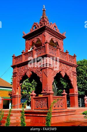 Lamphun, Thailand: Dekorative rote Trommel- und Glockenturm mit kreisförmigen Gong Drum hing in den offenen Bögen Stockfoto