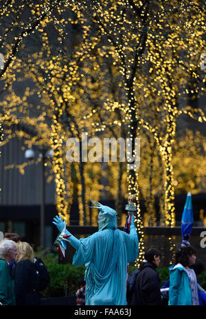 New York, USA. 24. Dezember 2015. A Street Performer gekleidet wie die Statue of Liberty-Posen mit Touristen für Bilder um Tipps am Times Square in New York City, USA, am 24. Dezember 2015 zu verdienen. New York City hatten ihre wärmsten Heiligabend auf Platte, wenn die Temperatur 72 Fahrenheit stieg Grad (22 Grad Celsius Grad) am Donnerstag. Bildnachweis: Wang Lei/Xinhua/Alamy Live-Nachrichten Stockfoto