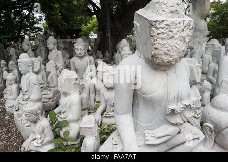 MANDALAY, Myanmar – lokale Handwerker machen die staubigen und rücksichtsvollen Arbeiten, die Statuen des Buddha aus Marmor schnitzen. Da der Buddhismus die dominierende Religion in Myanmar ist, besteht eine beträchtliche Nachfrage nach den Statuen, wobei Kunden aus einer Vielzahl von Posen, Größen und Stilen wählen können. Die Kunsthandwerker befinden sich in einer Straße im Chanmyathazi-Viertel Mandalay in der Nähe der Mahamuni-Pagode. Stockfoto